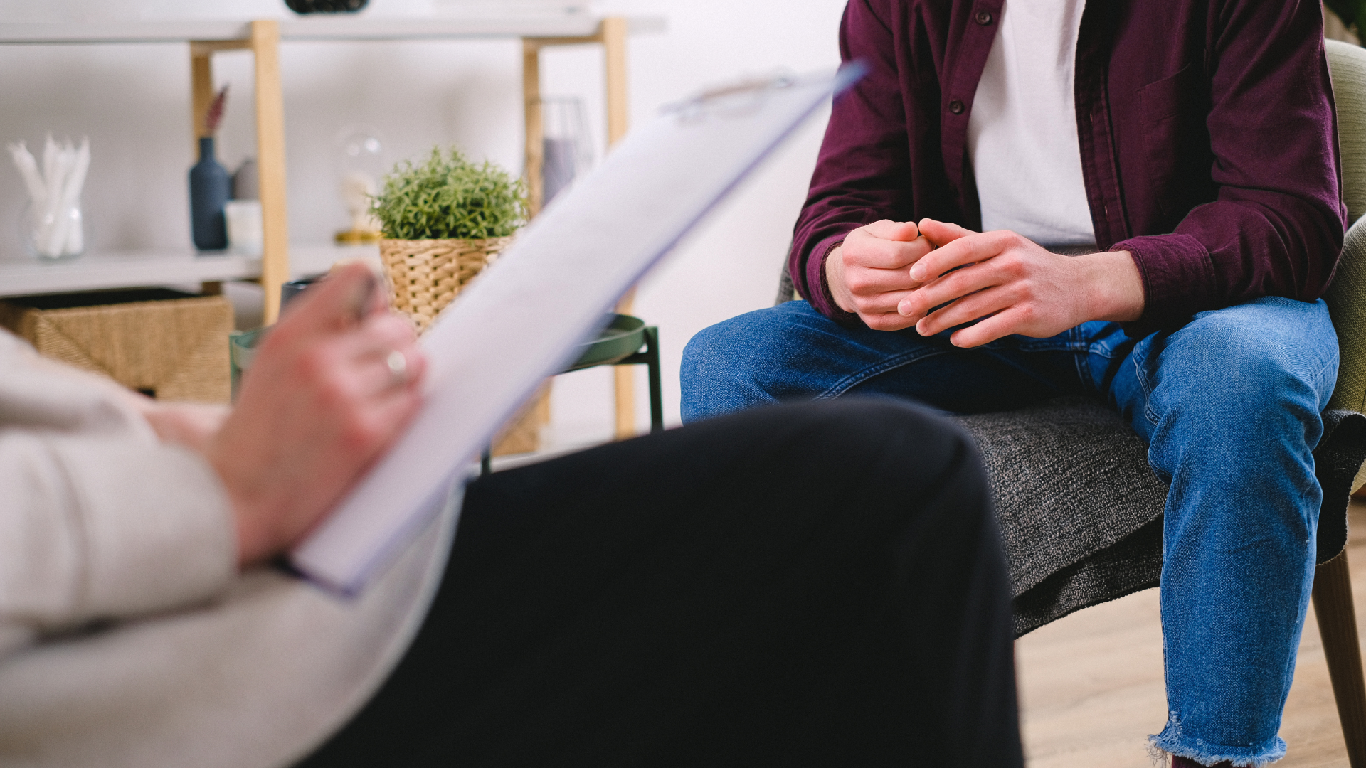 A therapy session focused on managing ADHD, showing a therapist taking notes while a client discusses challenges and solutions (tCaPC).