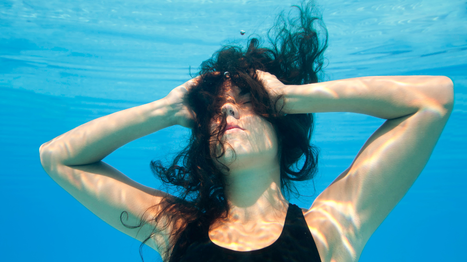 Image of a woman underwater, symbolizing escape from reality. Courtesy of tCaPC.